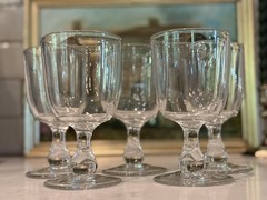 A set of five clear glass vintage cordial or small wine glasses.