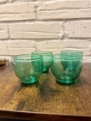 Set of four green glass roly poly style small bowls.