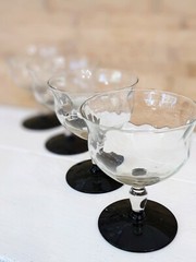 Vintage Weston glass black foot champagne glasses featuring wavy optic bowl.
