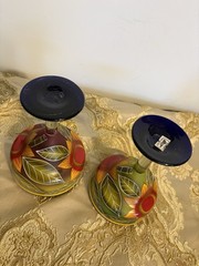 A pair of hand-painted glass margarita glasses with floral and leaf motifs.