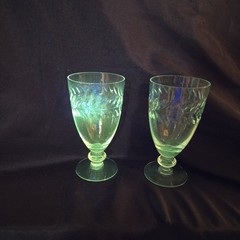 A pair of UV Reactive glass stemmed glasses with cut decoration.
