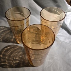 Vintage amber carnival glass tumblers with a swirling pattern