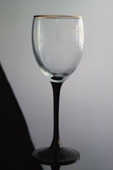 Contemporary wine glass with black stem , gold rim