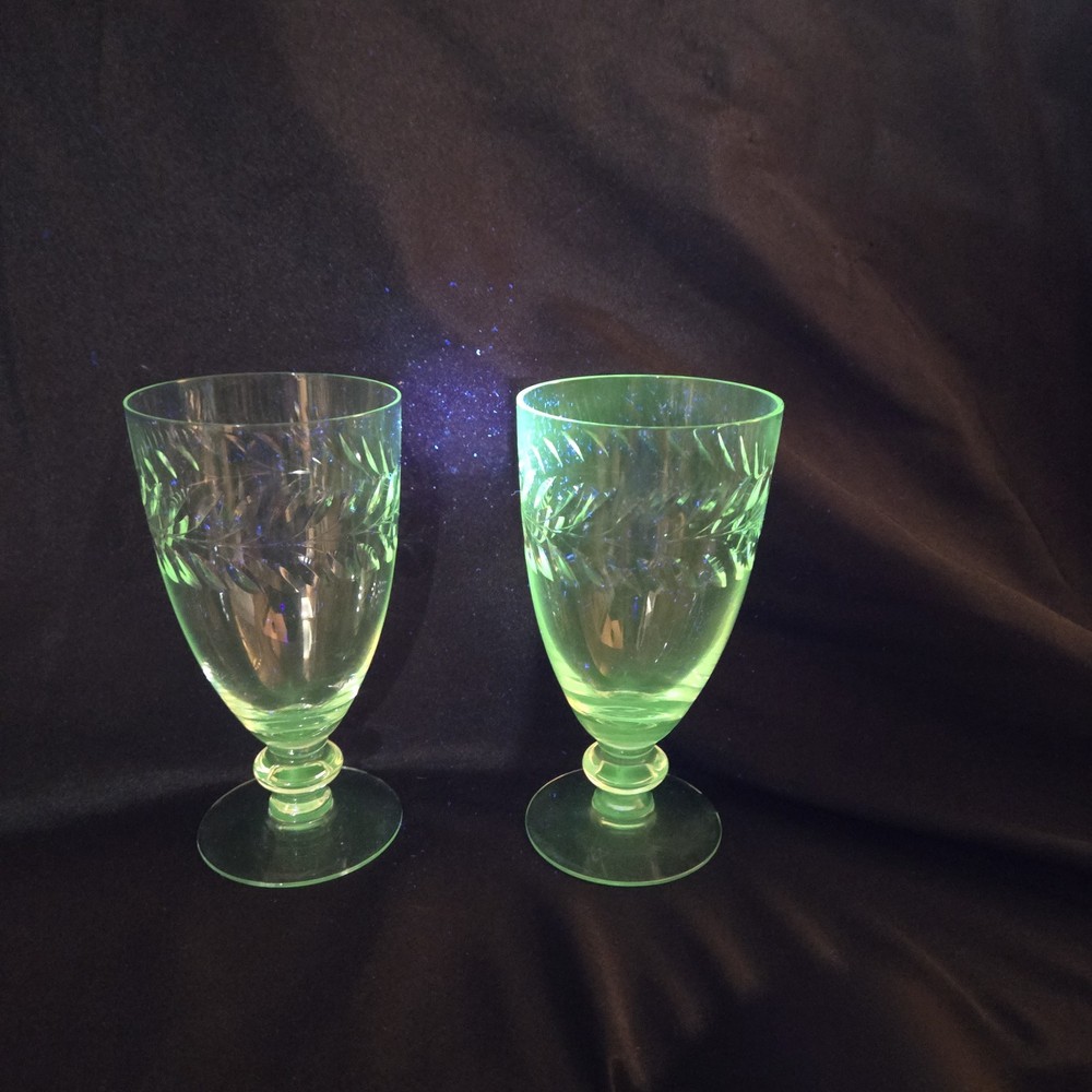 A pair of UV Reactive glass stemmed glasses with cut decoration.