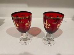 Two Ruby Red Wine Goblets with Gold Rims and Crown Insignias