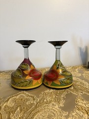 A pair of hand-painted glass margarita glasses with floral and leaf motifs.