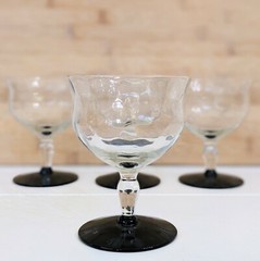 Vintage Weston glass black foot champagne glasses featuring wavy optic bowl.