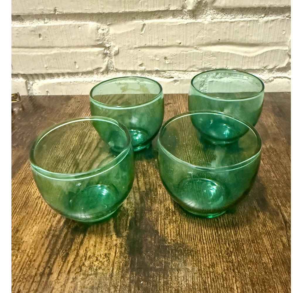 Set of four green glass roly poly style small bowls.