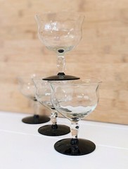 Vintage Weston glass black foot champagne glasses featuring wavy optic bowl.
