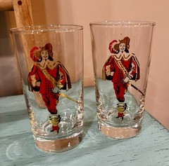 Pair of clear glass tumblers with historical figure graphic.