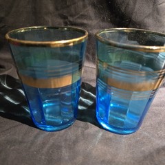 Blue glass tumblers with gold bands, likely MCM style