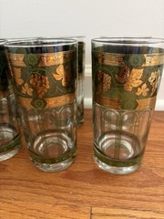 A Mid-Century Modern Cera Glass highball tumbler with a golden grape motif.