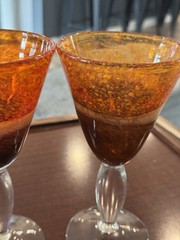 Handblown art glass stemmed goblets with orange, beige, and brown coloration